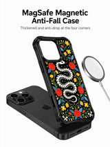 PhoneCasing iPhone 16 pro max Case with a white bone snake skeleton forming a symmetrical floral wreath, surrounded by red roses, yellow blooms and blue foliage, folk art print on durable black iPhone 16 pro max casing.