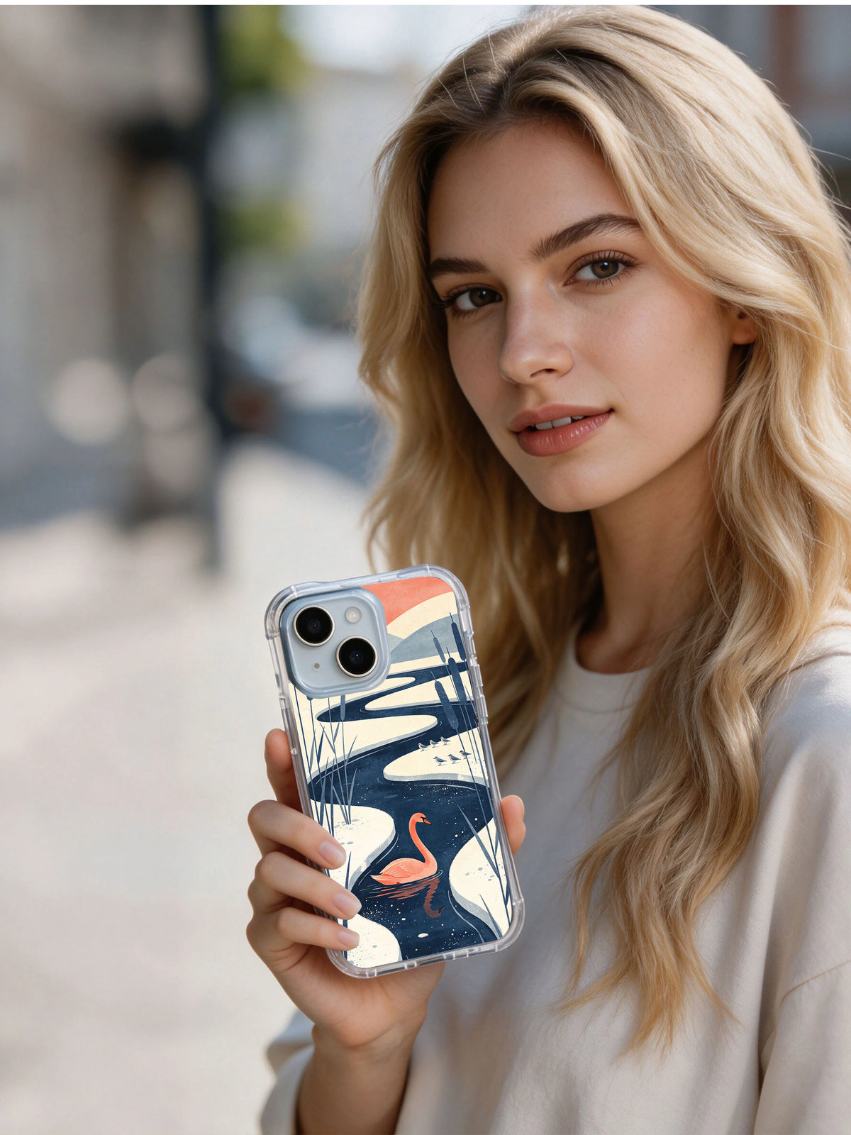Woman holding an iPhone 13 case with the coral swan winter lake design