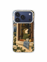 Olive green otter beside an open arched library window with warm books and foliage on an iPhone 17 Pro case