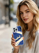 Lifestyle view of a person holding the Reindeer Pair Crossing artwork on a white iPhone 14 Pro case
