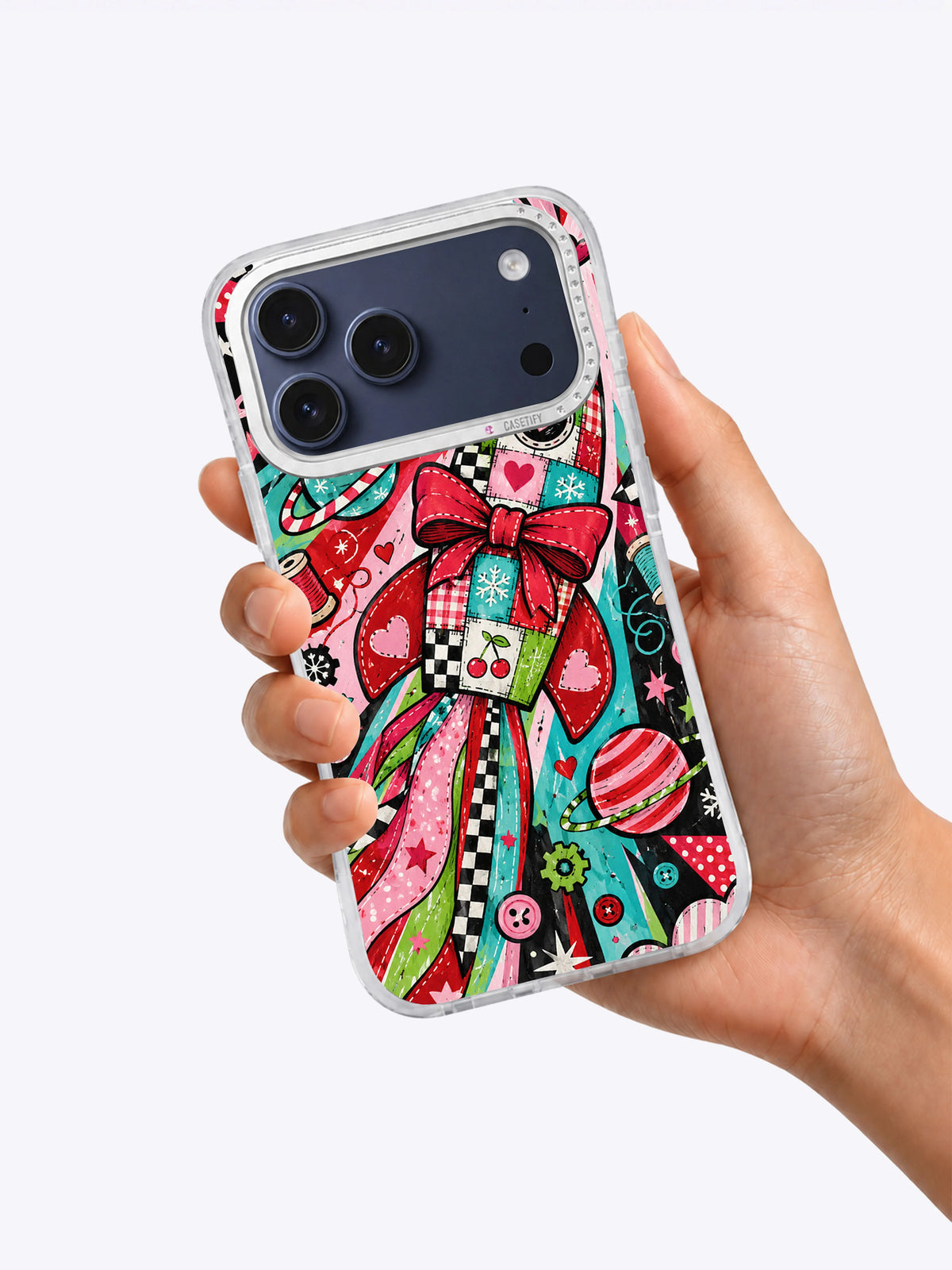 Ribbon Rocket Workshop iPhone 17 Pro Max case held in one hand showing the colorful bow rocket artwork
