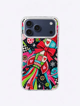 Starburst Gift Rocket artwork on an iPhone case with turquoise patchwork, cherry-red bow and fins, lime ribbons, buttons, planets, and black star field