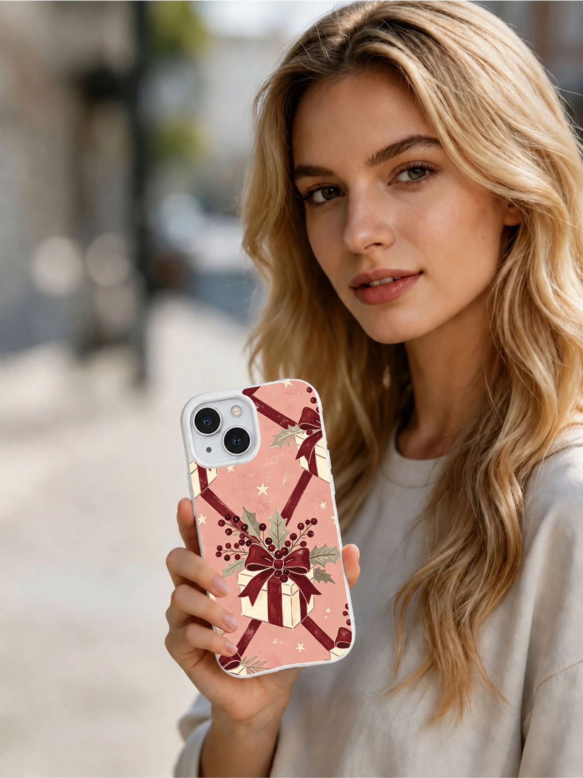 Person holding the Rose Ribbon Christmas iPhone 15 case