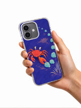 Hand holding the Sideways Is a Direction illustrated crab iPhone 17 case