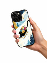 Hand holding the Sleigh Across the Blue Night iPhone 15 Pro case with black cat and winter gift artwork