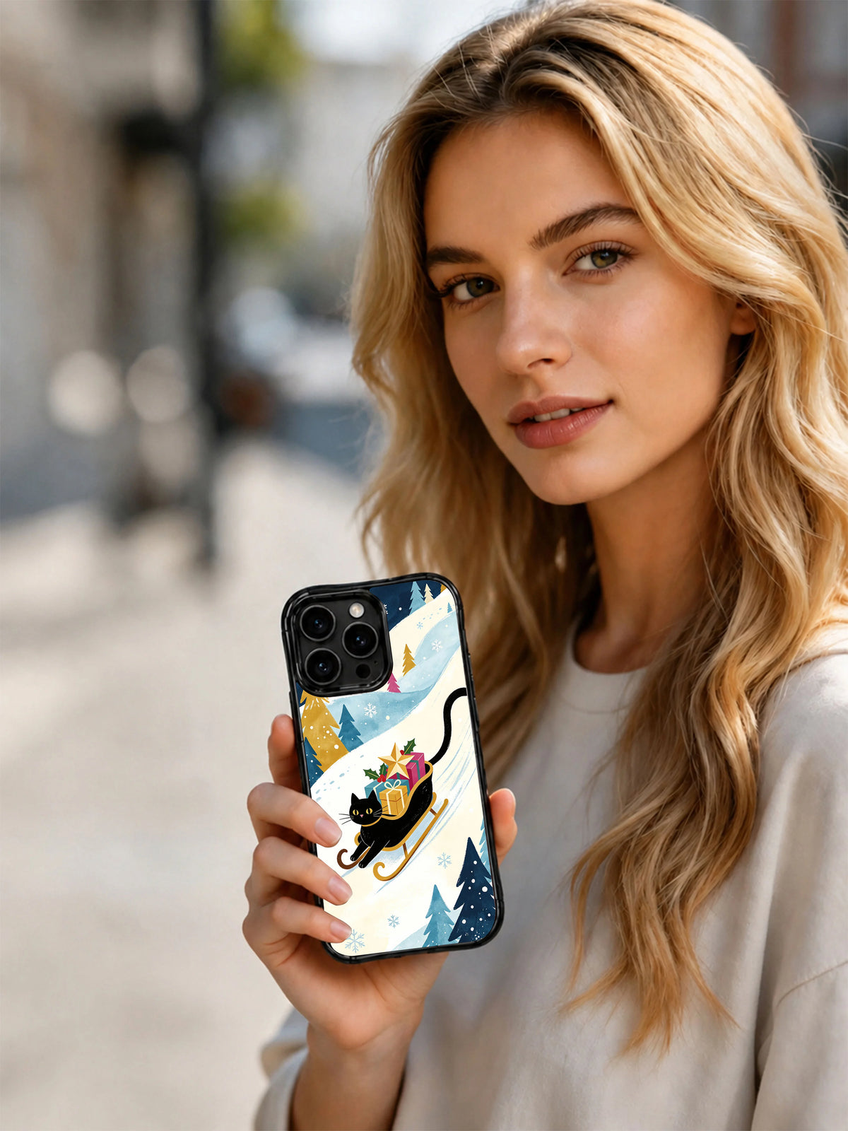 Lifestyle view of a person holding the Sleigh Across the Blue Night iPhone 15 Pro case with black cat sleigh art