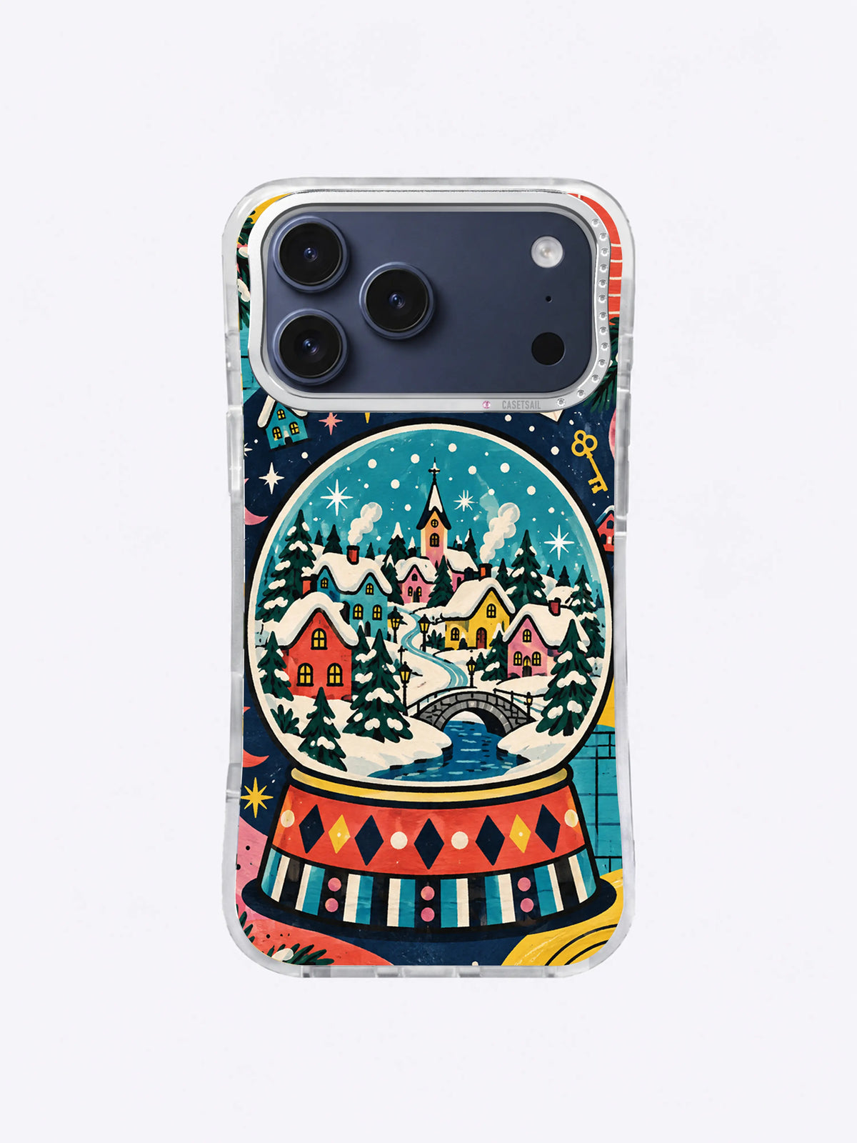 Golden Cottage Snow Globe artwork on an iPhone case with warm yellow cottages, a winding snowy path, stars, and multicolor base