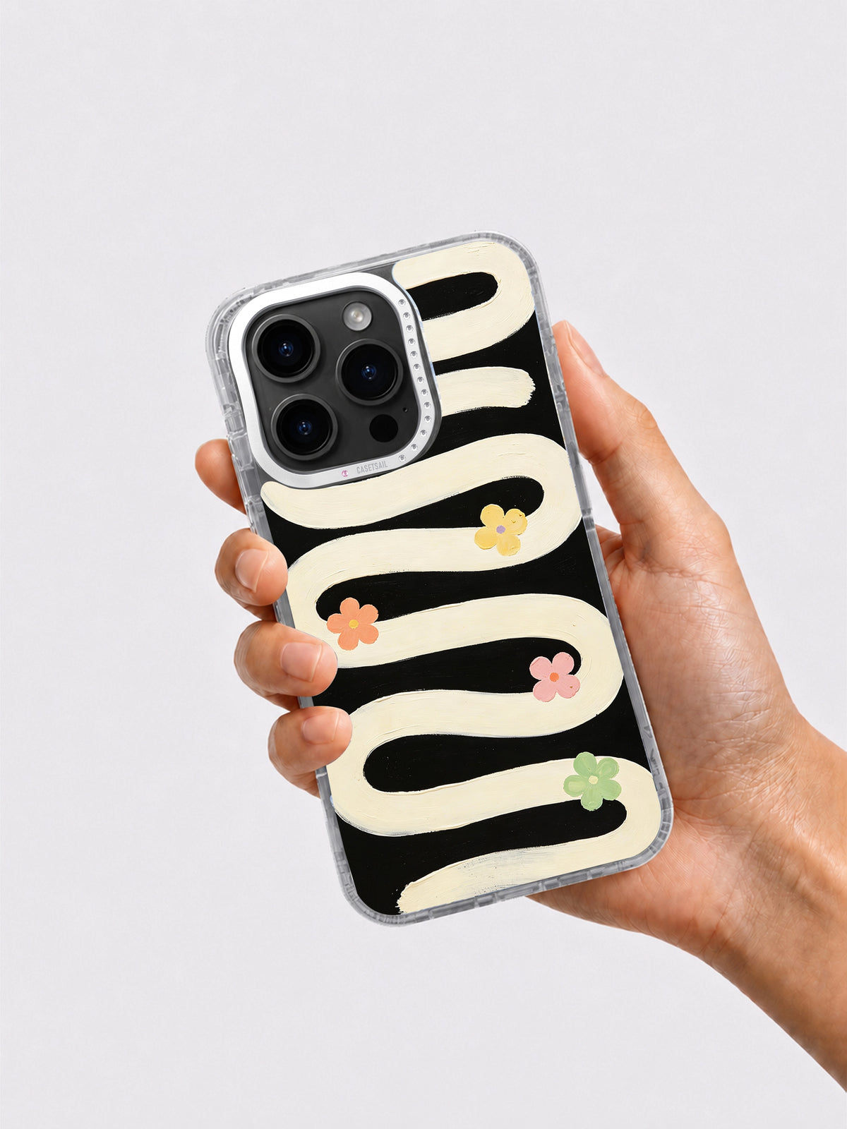 Black cream floral art phone case held in hand