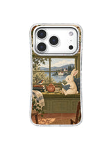 Cream rabbit reading beside books and tea at a rainy window phone case artwork
