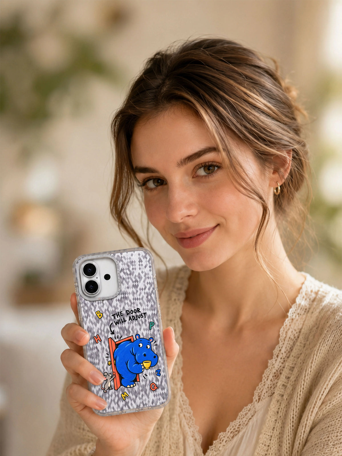 Lifestyle portrait with The Door Will Adjust hippo iPhone 16 case