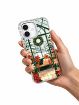 The Greenhouse of Red Blooms iPhone 17 case held in hand