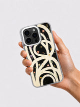 Hand holding black cream and colorful floral loop iPhone case