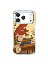 Brick-red bear leaning over mismatched cups and books on an iPhone 17 Pro case