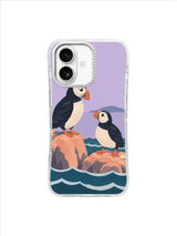 Black and ivory puffins with coral beaks resting above the tide on a pale lavender phone case