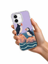 Hand holding the Two Seats Above the Tide puffin art iPhone 17 case