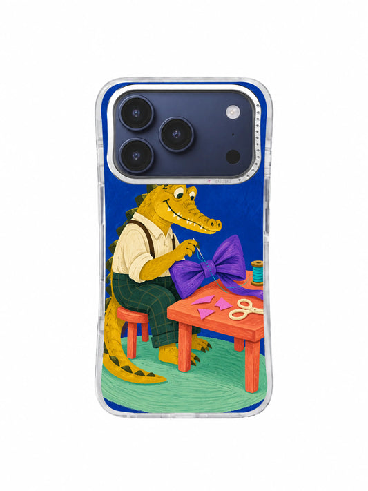 Mustard alligator tailor beginning a violet bow stitch on an iPhone 17 Pro case